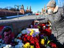 Menschen legen Blumen an dem Ort nieder, an dem der verstorbene Oppositionsführer Boris Nemzow am 27. Februar 2022, am siebten Jahrestag seiner Ermordung, auf einer Brücke in der Nähe des Kremls im Zentrum Moskaus tödlich erschossen wurde.