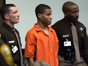 Sniper suspect Lee Boyd Malvo, 18, is surrounded by deputies as he is brought into court to be identified by a witness during the trial of sniper suspect John Allen Muhammad at the Virginia Beach Circuit Court in Virginia Beach, Virginia, October 22, 2003.