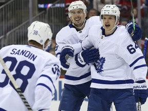 Toronto Maple Leafs centre David Kampf (64) celebrates with Justin Holl (3) and Rasmus Sandin (38) after scoring a goal against New Jersey Devils during the first period at Prudential Center Feb. 1, 2022.