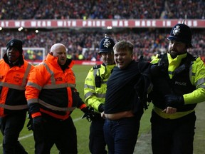 A fan is arrested by police after invading the pitch during a FA Cup match between Leicester City and Nottingham Forest at The City Ground in Nottingham, England, Sunday, Feb. 6, 2022.
