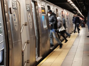 People board a subway on January 19, 2022 in New York City.