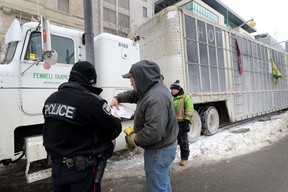 A trucker gets three tickets from the Ottawa Police on Elgin Street in Ottawa Sunday, Feb. 6, 2022.
