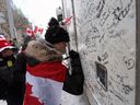 Unterstützer schreiben Nachrichten auf einen Lastwagen, während Demonstranten am 12. Februar 2022 in Ottawa weiterhin gegen die Covid-19-Mandate protestieren. 