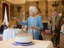 Königin Elizabeth II. schneidet am Samstag, dem 5. Februar 2022, während eines Empfangs im Ballsaal des Sandringham House in King's Lynn, England, einen Kuchen an, um den Beginn des Platinjubiläums zu feiern.