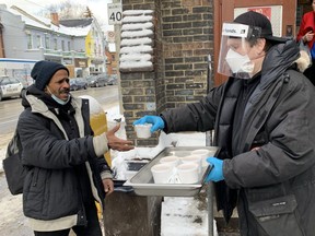 Community outreach member Rick McKinley hands a bowl of warm soup to Sultan Hamid, who is homeless and frequents the corner of Dundas and Sherbourne Sts. in the the city's Cabbagetown South neighbourhood.