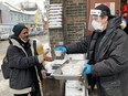 Community outreach member Rick McKinley hands a bowl of warm soup to Sultan Hamid, who is homeless and frequents the corner of Dundas and Sherbourne Sts. in the the city's Cabbagetown South neighbourhood.