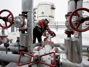 A worker turns a valve at UdmurtNeft's Gremikhinskoye oil field east of Izhevsk, Russia, Dec. 7, 2007.