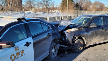 The Ontario Provincial Police say a cruiser was hit by a car while an officer was investigating a minor collision.