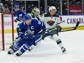 Maple Leafs' John Tavares (left) and Minnesota Wild's Jared Spurgeon battle for position during the third period at Scotiabank Arena on Thursday, Feb. 24, 2022.