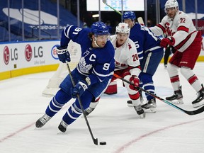 Toronto Maple Leafs forward John Tavares controls the puck against Carolina Hurricanes forward Sebastian Aho during the first period at Scotiabank Arena in Toronto, Feb. 7, 2022.