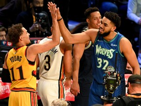 Karl-Anthony Towns of the Minnesota Timberwolves celebrates with Trae Young of the Atlanta Hawks at Rocket Mortgage Fieldhouse on February 19, 2022 in Cleveland, Ohio.