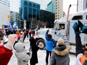 People show their support for a trucker who leaves on Feb. 19, 2022 as police in Ottawa work to restore normality to the capital after trucks and demonstrators occupied the downtown core for more than three weeks to protest against pandemic restrictions.
