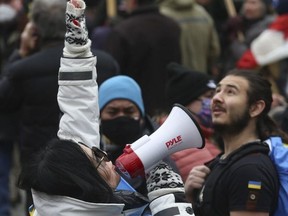 Natalia Halych uses a megaphone to denounce Russia's invastion of Ukraine during a massive demonstration in downtown Toronto on Feb. 27, 2022