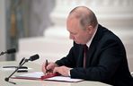 Der russische Präsident Wladimir Putin unterzeichnet Dokumente, darunter ein Dekret, das zwei von Russland unterstützte abtrünnige Regionen in der Ostukraine als unabhängige Einheiten anerkennt, während einer Zeremonie in Moskau, auf diesem Bild, das am 21. Februar 2022 veröffentlicht wurde.  