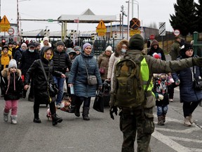 Menschen aus der Ukraine überqueren am Samstag, 5. März 2022, die ukrainisch-polnische Grenze in Korczowa, Polen.