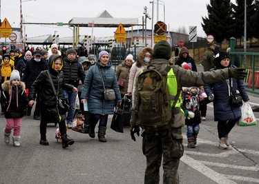 People coming from Ukraine cross the Ukrainian-Polish border in Korczowa, Poland, Saturday, March 5, 2022.