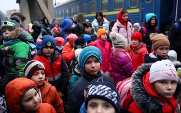 A group of children evacuated from an orphanage in Zaporizhzhia wait to board a bus for their transfer to Poland after fleeing the ongoing Russian invasion at the main train station in Lviv, Ukraine, Saturday, March 5, 2022.