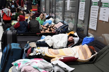 People rest at a refugee reception centre at the Ukrainian-Polish border crossing in Korczowa, Poland, Saturday, March 5, 2022.