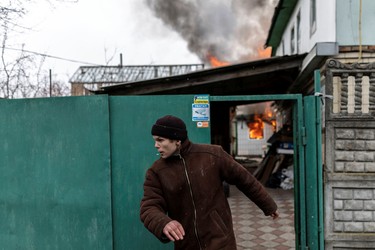A local resident reacts as a house is on fire after heavy shelling on the only escape route used by locals to leave the town of Irpin, while Russian troops advance towards the capital, 24 km from Kyiv, Ukraine, Sunday, March 6, 2022.