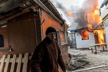 A local resident reacts as a house is on fire after heavy shelling on the only escape route used by locals to leave the town of Irpin, while Russian troops advance towards the capital, 24km from Kyiv, Ukraine March 6, 2022. REUTERS/Carlos Barria