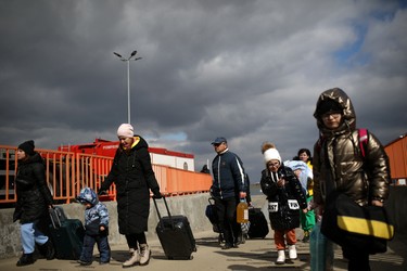 People arrive by ferry after fleeing from Russia's invasion of Ukraine, at the Isaccea-Orlivka border crossing, Romania, Sunday, March 6, 2022.