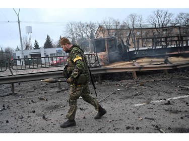 Ukrainian service members collect unexploded shells after a fighting with Russian raiding group in the Ukrainian capital of Kyiv in the morning of Feb. 26, 2022, according to Ukrainian service personnel at the scene.