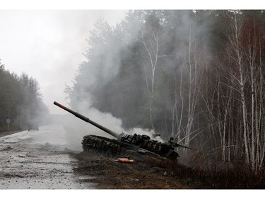 Smoke rises from a Russian tank destroyed by the Ukrainian forces on the side of a road in Lugansk region on Feb. 26, 2022.