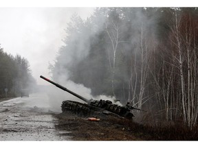 Rauch steigt aus einem russischen Panzer auf, der am 26. Februar 2022 am Rand einer Straße in der Region Lugansk von ukrainischen Streitkräften zerstört wurde.