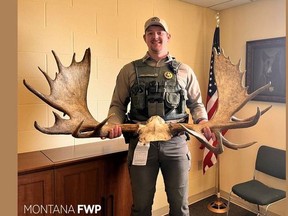 This Facebook photo shows Game Warden Josh Leonard with the antlers of a moose that was shot, beheaded and abandoned by a hunter