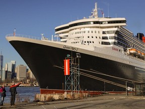 People look toward the Queen Mary 2 cruise ship by Cunard Line, owned by Carnival Corporation & plc. as it sits docked at Brooklyn Cruise Terminal in Brooklyn, New York City, U.S., December 20, 2021.