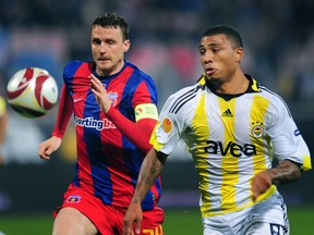 Kazim Kazim (R) of Fenerbahce SK vies for the ball along with Sorin Ghionea (L) of FC Steaua Bucuresti during the Europa League football match of in Bucharest October 22, 2009.