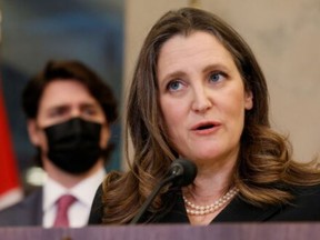 Deputy Prime Minister Chrystia Freeland pictured at a press conference on Feb. 14, 2022 when Prime Minister Justice Trudeau (behind) invoked the Emergencies Act.