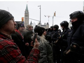 Kanadische Polizeibeamte stehen Demonstranten gegenüber, während sie daran arbeiten, die Normalität in der Hauptstadt wiederherzustellen, während Lastwagen und Demonstranten den Kern der Innenstadt mehr als drei Wochen lang besetzen, um gegen Pandemiebeschränkungen in Ottawa, Ontario, Kanada, am 19. Februar 2022 zu protestieren.