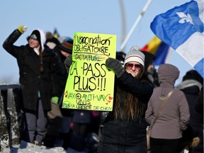People supporting the trucker convoy protest gather above Highway 20 in Boucherville Jan. 28, 2022.