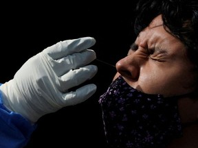 A health worker collects a swab sample from a man to test for the coronavirus disease (COVID-19) as the pandemic continues in Mexico City, Mexico, January 20, 2022.