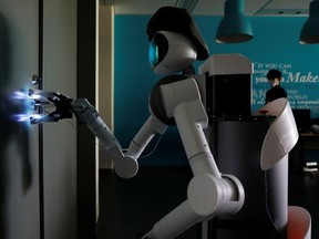 Mira Robotics’ Ugo avatar robot sterilizes a door handle with ultraviolet light during a demonstration at the company’s laboratory in Kawasaki, Japan, on June 8, 2020.