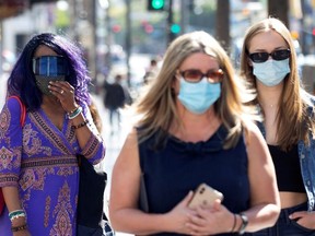 People wearing face protective masks walk on Hollywood Blvd. during the outbreak of COVID-19 in Los Angeles, Calif., March 29, 2021.