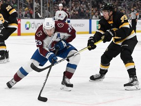 Boston Bruins defenseman Charlie McAvoy defends Colorado Avalanche center Nathan MacKinnon during the second period at the TD Garden.