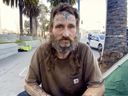 Homeless man with face tattoos being interviewed
