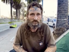 Homeless man with face tattoos being interviewed