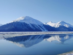The mountains are reflected at Turnagain Arm on the outskirts of Anchorage, Alaska.