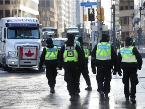 Police patrol downtown Ottawa as a protest against COVID-19 public health measures enters its 11th day, with trucks and other vehicles blocking several streets.