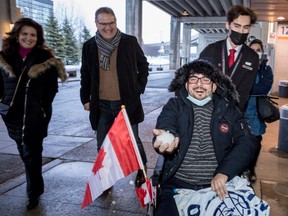 Retired Canadian Forces Lt.-Col. Tony White and his wife Simonne share a laugh as Afghan interpreter Ahmad Seyar Sadiqi, aka Radar, gets a kick out of making a snowball after arriving in Ottawa with his wife and three kids on Thursday, Feb. 11, 2022.