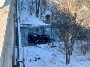 A badly damaged pickup truck came to rest in the Don River after plunging from the westbound lanes of Hwy. 401 near Leslie St. on Saturday, Feb. 26, 2022.