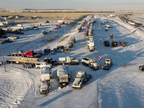 A truck convoy of anti-COVID-19 vaccine mandate demonstrators continue to block the highway at the busy U.S. border crossing in Coutts, Alta., Wednesday, Feb. 2, 2022.