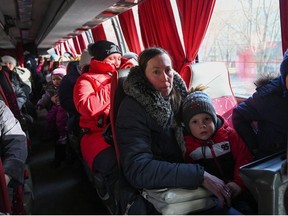 People, who were evacuated from separatist-controlled regions in eastern Ukraine, sit in a bus as they arrive at a railway station to leave the city of Taganrog in the Rostov region, Russia February 20, 2022.
