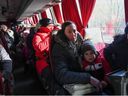 Menschen, die aus von Separatisten kontrollierten Regionen in der Ostukraine evakuiert wurden, sitzen in einem Bus, als sie an einem Bahnhof ankommen, um die Stadt Taganrog in der Region Rostow, Russland, am 20. Februar 2022 zu verlassen.  