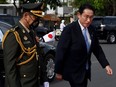 Japan's Prime Minister Fumio Kishida (R) walks beside Cambodian general Po Sabuddy at the Independent Monument in Phnom Penh on March 20, 2022.