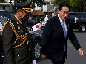 Japan's Prime Minister Fumio Kishida (R) walks beside Cambodian general Po Sabuddy at the Independent Monument in Phnom Penh on March 20, 2022.