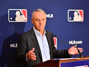 Major League Baseball commissioner Rob Manfred answers questions during a news conference.